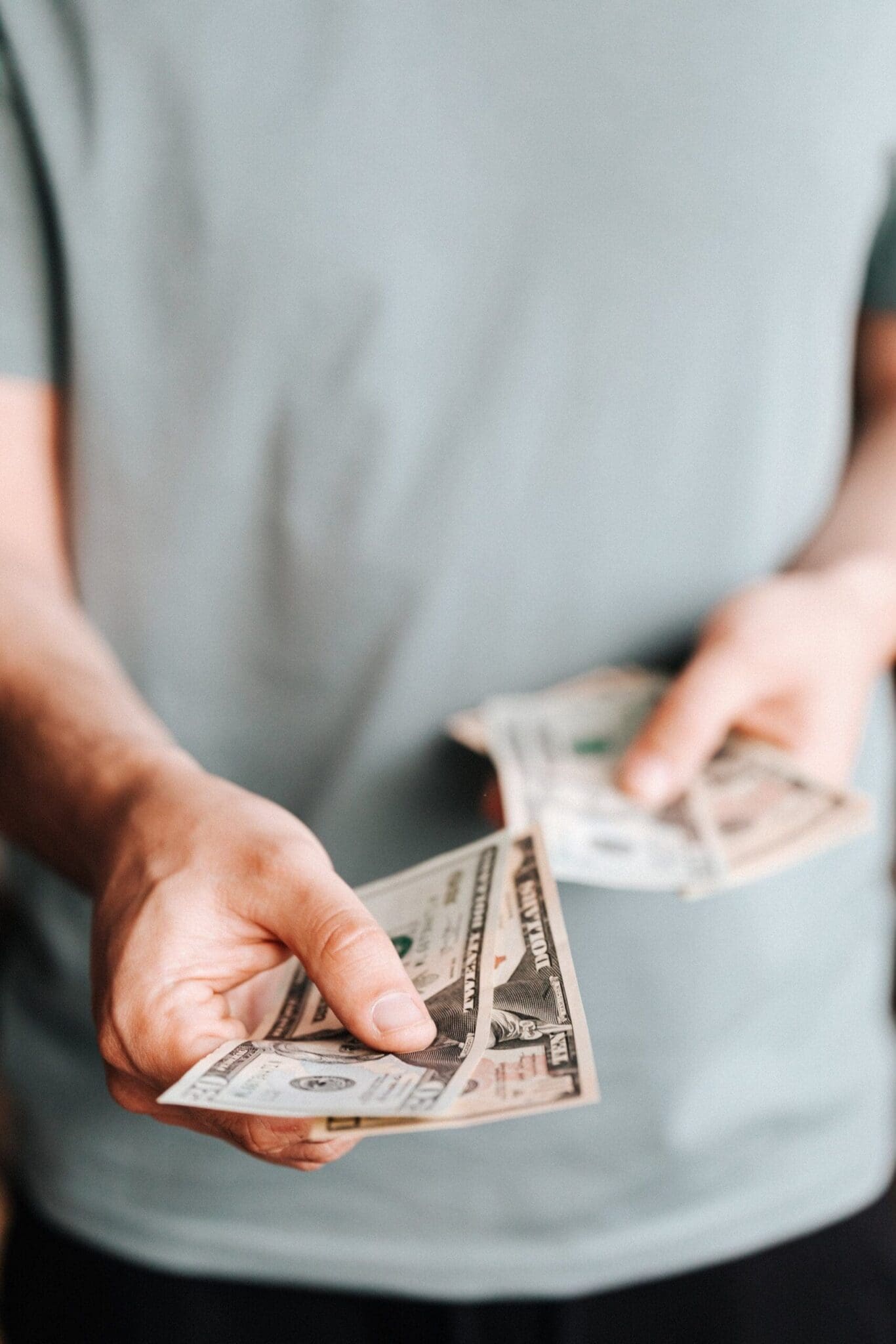 Homeowner counting out cash to pay for New Jersey lawn care services